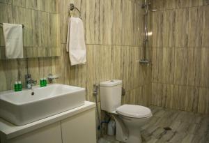 a bathroom with a white toilet and a sink at Arena Hotel Beylagan in Beylǝqan +14 photos