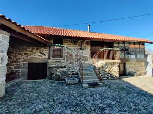 a stone house with a staircase in front of it at Casa das Falagueiras in Castro Laboreiro +40 photos