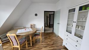 a dining room with a wooden table and chairs at Mi Casa Es Su Casa - 2 Zimmerwohnung mit Tiefgaragenparkplatz in Krumbach