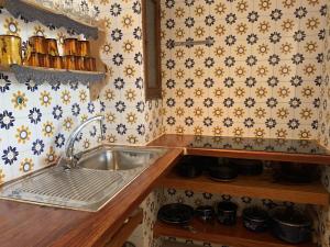 a kitchen with a sink and a floral wallpaper at Borras in Es Pujols