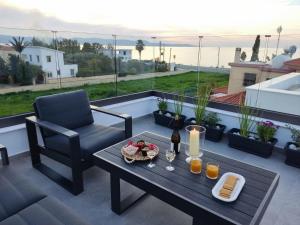 a patio with a table and a chair on a balcony at New Luxury Georgia Beach Villa II in Argaka