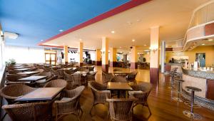un restaurante con un montón de mesas y sillas en Hotel Monarque Torreblanca, en Fuengirola