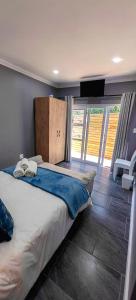 a bedroom with a large bed and a large window at Hartklop Luxury Self Catering Guesthouse in Linkside