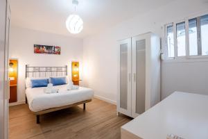 a white bedroom with a bed and a window at Casa con encanto - Wifi, aire acondicionado in Puerto Real