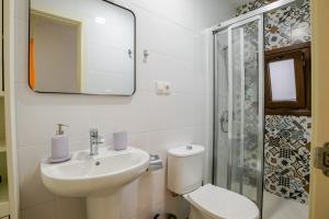 a bathroom with a sink and a toilet and a mirror at Casa con encanto - Wifi, aire acondicionado in Puerto Real +21 photos