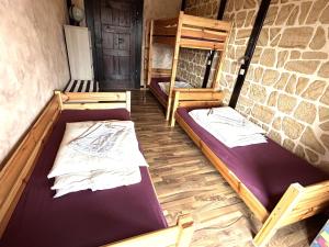 two bunk beds in a room with a stone wall at Familienfreundliche Ferienwohnung GERICHTSSTUBE im Rittergut bei Dresden für 6 Pers in Wachau