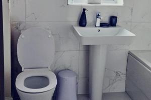 a white bathroom with a toilet and a sink at Luxury Getaway in Preston with 5 Bedrooms in Preston
