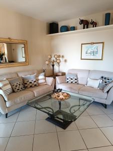 a living room with a couch and a glass table at Villa Adriana in Capoliveri