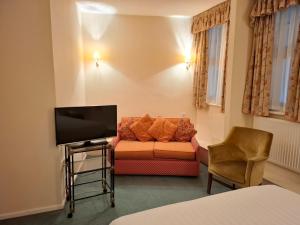 a living room with a couch and a tv at Borough Arms Hotel in Stoke on Trent