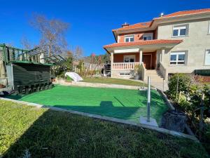 a yard with a putting green in front of a house at Chalet Miracies in Hio