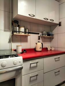 a kitchen with a red counter top with a stove at 2 dormitorios, 2 baños in Santiago