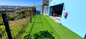 a garden with grass on the side of a house at Hartklop Luxury Self Catering Guesthouse in Linkside