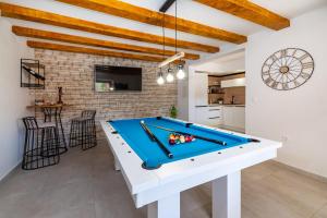 a pool table in a living room with a kitchen at Villa Ivan in Pridraga