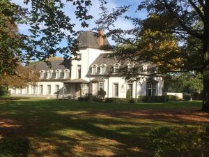 a large white house with a large yard at Acacia 103 in Aan de Wolfsberg