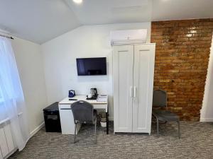 a room with a desk with a computer and two chairs at Grey apartments "Easy Kaunas" in Kaunas