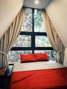 a bedroom with a red bed and a window at Kayla Homestay - Bungalow Rose Đôi in Ba Vì