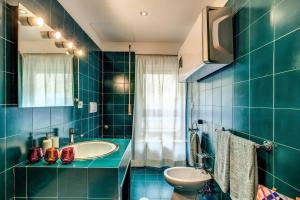 W wyłożonej niebieskimi kafelkami łazience znajduje się umywalka i toaleta. w obiekcie Lovely apartment close Vatican w Rzymie