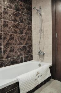 a bath tub with a shower in a bathroom at Axxodia- Duplex Porto New Cairo in Cairo