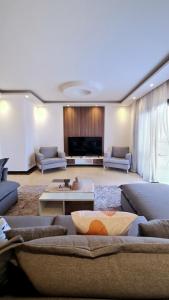 a large living room with couches and a tv at Axxodia- Duplex Porto New Cairo in Cairo