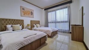 a hotel room with two beds and a window at Axxodia- Duplex Porto New Cairo in Cairo +39 photos