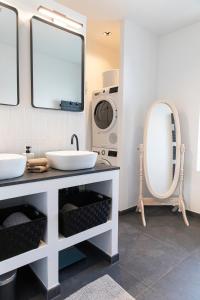 ein Badezimmer mit 2 Waschbecken und einer Waschmaschine in der Unterkunft Appartement historique Dior in Granville