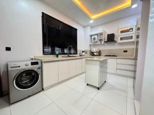 una cocina con lavadora y lavadora en Luxury 2Bed 2Bathroom in Ikate Lekki, en Lekki 3 fotos más