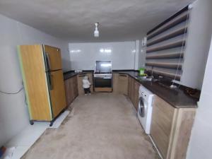 a kitchen with a refrigerator and a washer and dryer at شقة مفروشة في عجلون رأس منيف in Ajloun