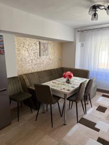 a dining room with a table and chairs and a couch at Apartament cozy in Drăgăşani