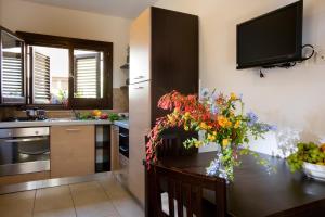 una cocina con una mesa con un jarrón de flores. en Il Borgo Del Principino en Favignana