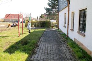 a person standing on a playground next to a building at Ferienwohnungen Berner in Droyßig