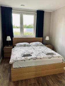 a bedroom with a large bed with a window at Stara Fabryka Myślniew in Myślniew