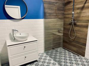 a bathroom with a sink and a mirror and a shower at Stara Fabryka Myślniew in Myślniew