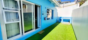 a hallway of a house with blue walls and green grass at Hartklop Luxury Self Catering Guesthouse in Linkside