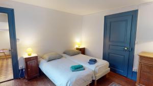 a bedroom with a large white bed with blue doors at Les appartements hyper centre Barr in Barr