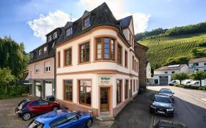 a building with cars parked in front of it at DTV-zertifizierte Ferienwohnung Kleine Moselruhe - zentral, für 3 Personen, Parkplatz & WLAN in Traben-Trarbach