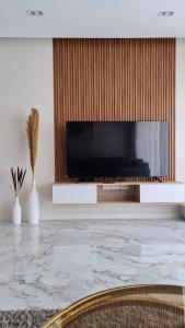 TV at/o entertainment center sa Axxodia- Apartments In Lake View Residence
