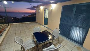a table and chairs on a balcony with a view of the ocean at Estúdio Laura in Câmara de Lobos