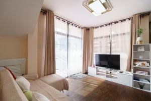 un soggiorno con divano e TV a schermo piatto di Charming 3-Storey house near BTS Onnut Station a Bangkok