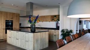 a kitchen with a island with a vase of flowers on it at Vakantiewoning De Stoep in Appeltern +6 photos