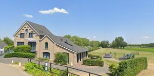 a house with a car parked in front of it at Vakantiewoning De Stoep in Appeltern