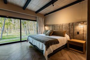 a bedroom with a bed and a large window at House by Casa Septem in Tupungato +31 photos