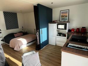 a bedroom with a bed and a desk with a keyboard at Ty Nid d'Amour Ty Mamou in Névez +13 photos