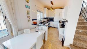 une cuisine avec des placards blancs et un escalier dans l'établissement Villa Pinos - A Murcia Holiday Rentals Property, à Sucina