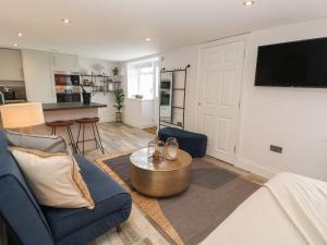 a living room with a blue couch and a table at The Beach Apartment in South Shields