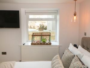 a living room with a window and a bed and a radiator at The Beach Apartment in South Shields
