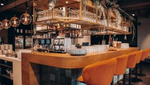 a bar with orange chairs in a restaurant at B&B kamer KOECK in Maasbommel