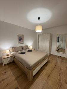 a bedroom with a large bed with two lamps on it at Matea Apartment in Čitluk