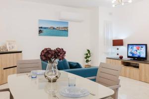 a living room with a white table and chairs at Mellieha 1bed With Outside Terrace By Homely! in Ix-Xagħra taʼ Barra