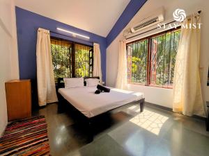 a bedroom with a bed with a cat laying on it at Sea Olive Villa - Stay Mist in Nagaon