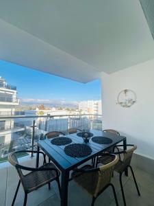 a dining room table with chairs and a large window at Aguacate Costa Tropical Apartamento in Motril